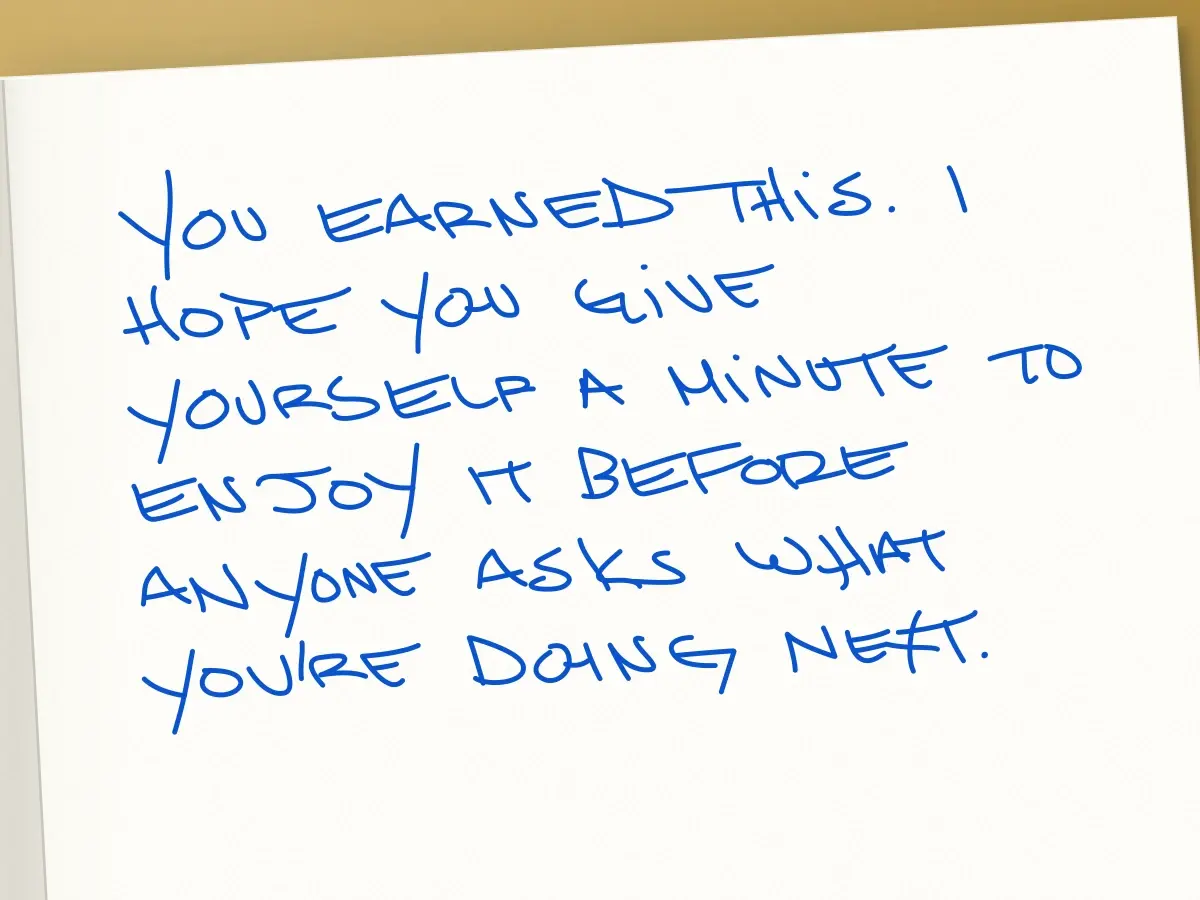 Handwritten card in Dean: You earned this. I hope you give yourself a minute to enjoy it before anyone asks what you're doing next.