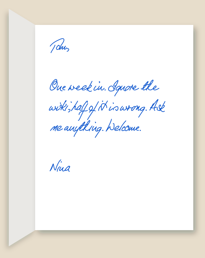 The inside of a handwritten card reading: Tom, One week in. Ignore the wiki, half of it is wrong. Ask me anything. Welcome. Nina