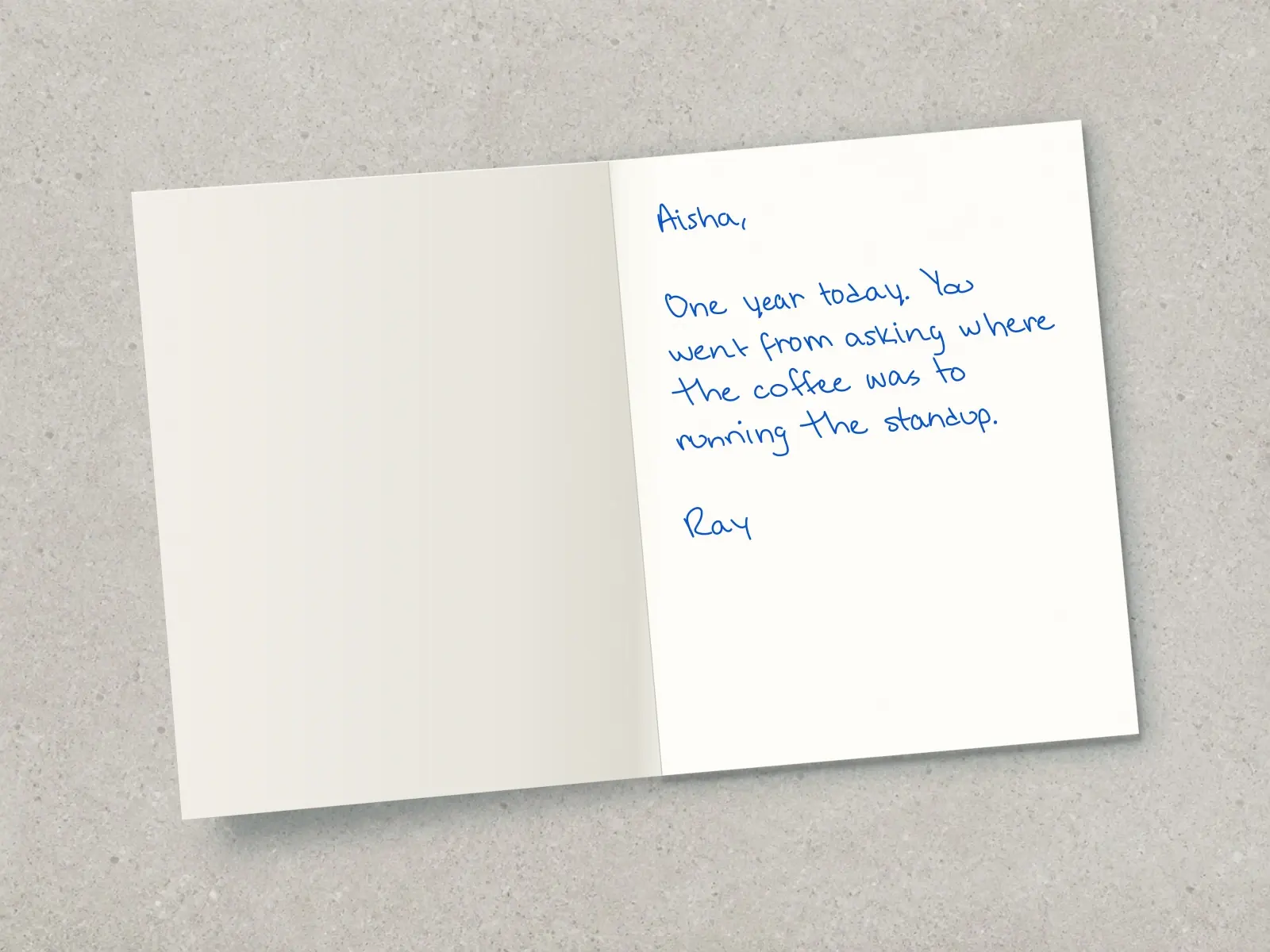 The inside of a handwritten card reading: Aisha, One year today. You went from asking where the coffee was to running the standup. Ray